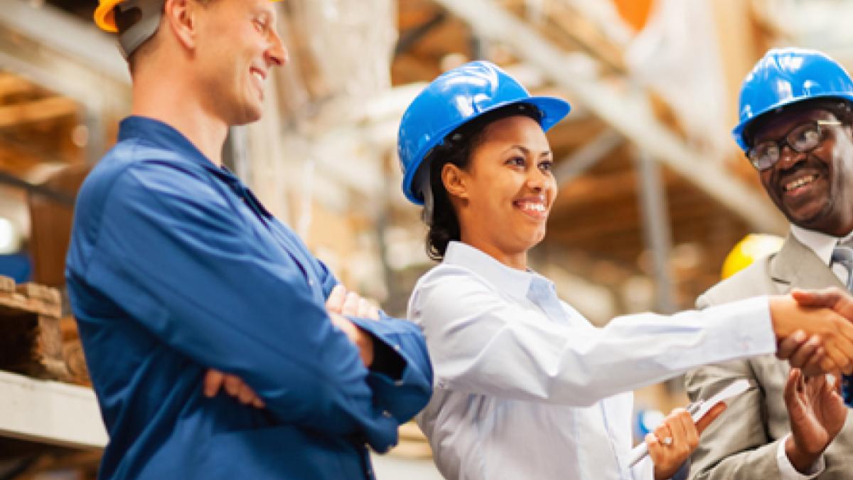 Warehouse manager shaking hands with warehouse worker